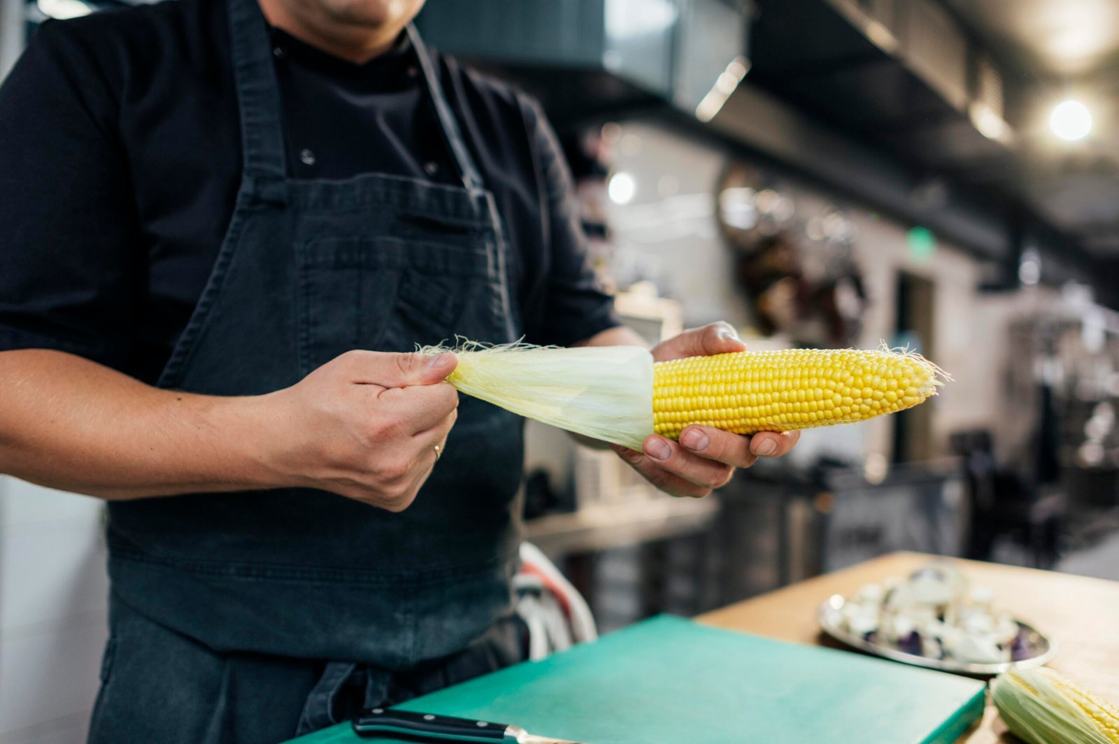 male chef cleaning corn cob scaled.jpg